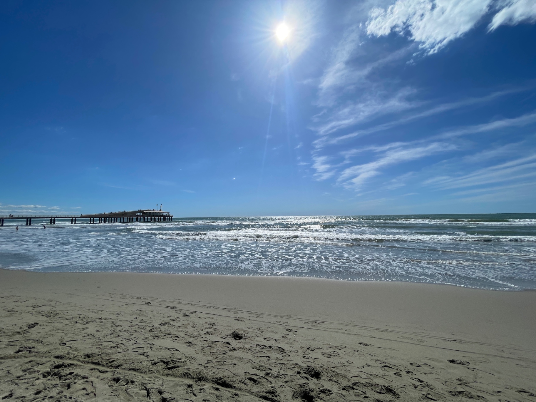 Pontile di Lido di Camaiore visto dalla riva, sole sul Tirreno
