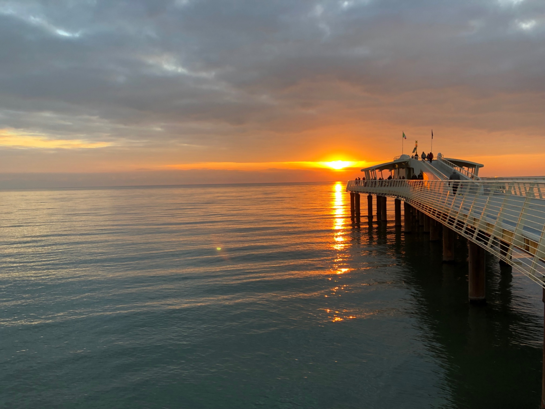 Sole sul mare al tramonto dal pontile